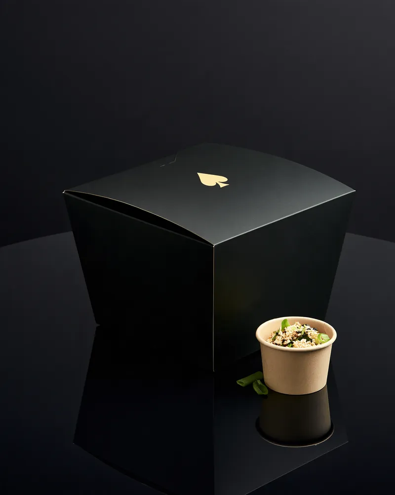 Jackpot Wings black folded fiber box with a gold spade mark.
